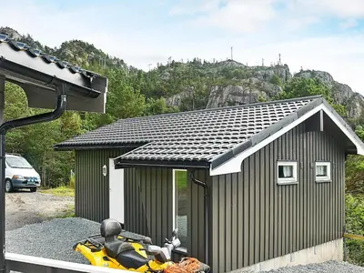 a small shed with a motorcycle parked in front of it at 8 person holiday home in Sundlandet in Snildal