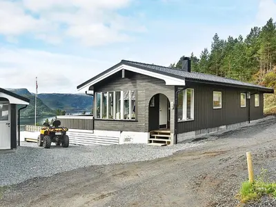 a small house with a motorcycle parked in front of it at 8 person holiday home in Sundlandet in Snildal