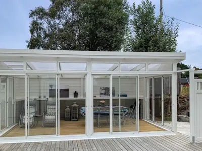 a conservatory with glass doors and a table on a deck at 10 person holiday home in Tornes I Romsdal in Tornes