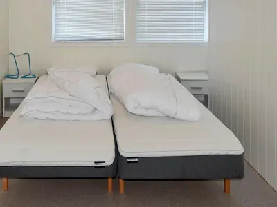 two beds in a room with white sheets and pillows at 8 person holiday home in Oksvoll in Oksvoll