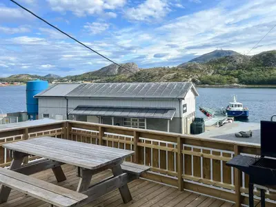a wooden deck with a picnic table and a boat at 8 person holiday home in Oksvoll in Oksvoll