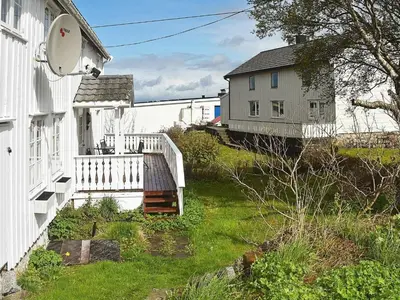 a yard with a white house and a building at 8 person holiday home in averøy in Henda
