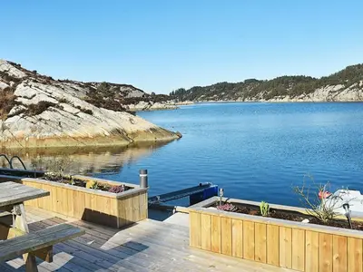 a dock with two planters on a body of water at 8 person holiday home in Urangsvåg in Ervik