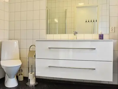 a white bathroom with a sink and a toilet at 8 person holiday home in Urangsvåg in Ervik