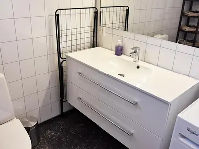 a white bathroom with a sink and a mirror at 8 person holiday home in Urangsvåg in Ervik