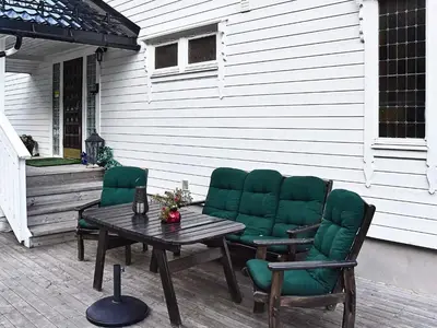 a patio with green chairs and a wooden table at 10 person holiday home in Folkestad in Folkestad