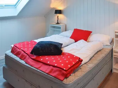 a bed with red and white blankets on it at 10 person holiday home in Folkestad in Folkestad
