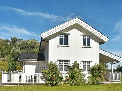 a white house with a white fence in front of it at 8 person holiday home in Oksvoll in Oksvoll