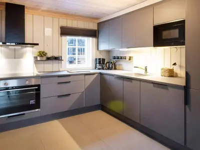 a large kitchen with gray cabinets and a window at 10 person holiday home in Fåvang in Strande