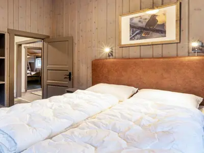 a large white bed in a bedroom with a picture on the wall at 10 person holiday home in Fåvang in Strande