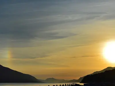 a sunset over a body of water with mountains at 10 person holiday home in EIDSVÅG in Rød