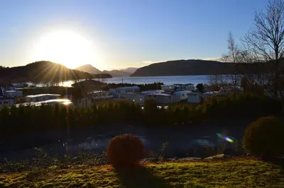 a sunset over a town next to a body of water at VIKEDAL VERTSHUS hotel in Vikedal