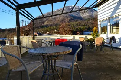a table and chairs on a patio with a view at VIKEDAL VERTSHUS hotel in Vikedal