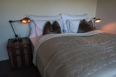 a bedroom with a bed with two pairs of shoes on it at Blåtind Boutique Hotel in Stordal