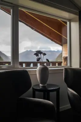 a vase on a table in front of a window at Blåtind Boutique Hotel in Stordal