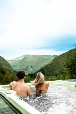 a man and a woman sitting in a hot tub at Blåtind Boutique Hotel in Stordal