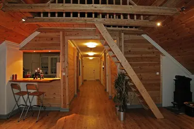 a room with a staircase in a house with wooden ceilings at Vikinghaug in Odda
