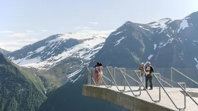 a group of people standing on the edge of a viewing platform overlooking mountains at Viken Holiday Home in Viksdalen