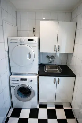 a small kitchen with a washing machine and a sink at Viken Holiday Home in Viksdalen