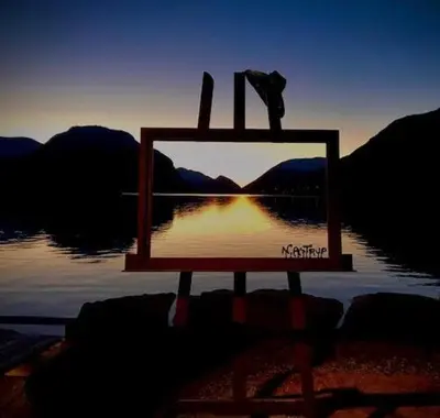 a picture of the sun reflecting in the water at Kjøsnes Feriehytter in Skei
