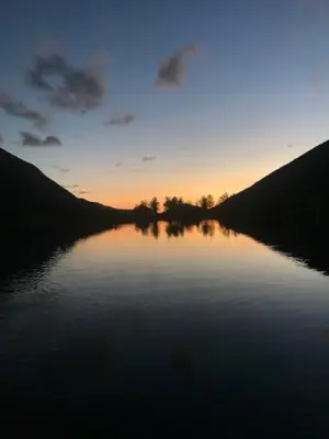 a body of water with the sunset in the background at Kjøsnes Feriehytter in Skei