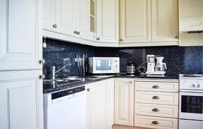 a kitchen with white cabinets and a sink and a microwave at 3 Bedroom Stunning Home In Bjoa in Utbjoa
