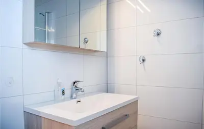a white bathroom with a sink and a mirror at 3 Bedroom Stunning Home In Bjoa in Utbjoa