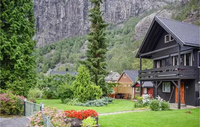 a house with a garden in front of a mountain at 3 Bedroom Lovely Home In Fjæra in Fjæra