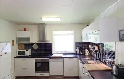 a kitchen with white cabinets and a window at 3 Bedroom Lovely Home In Fjæra in Fjæra
