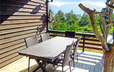 a wooden table and chairs on a deck at Gorgeous Home In Matre With Wifi in Hamre