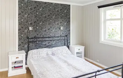 a bedroom with a bed with a black and white wall at Gorgeous Home In Matre With Wifi in Hamre
