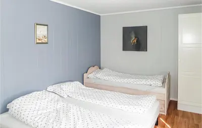 two beds in a room with blue walls at 2 Bedroom Gorgeous Home In Sveio in Sveio