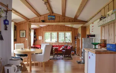 a kitchen and living room with a table and chairs at Three-Bedroom Holiday Home In Heidal in Heidal