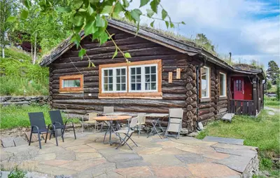 a table and chairs outside of a log cabin at Three-Bedroom Holiday Home In Heidal in Heidal