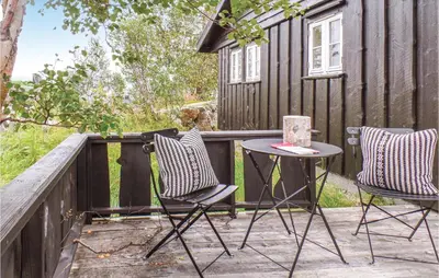a patio with two chairs and a table on a fence at Pet Friendly Home In Hovden With Sauna in Hovden