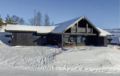a building with snow on the ground in front of it at Nice Home In Hovden With Sauna in Hovden