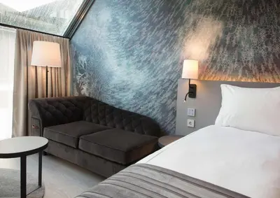 a hotel room with a bed and a couch at Scandic Flesland Airport in Bergen