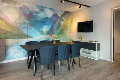 a dining room with a table and blue chairs at Scandic Flesland Airport in Bergen