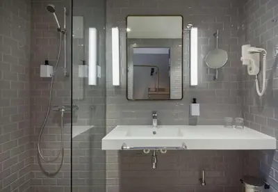 a bathroom with a sink and a shower and a mirror at Scandic Flesland Airport in Bergen
