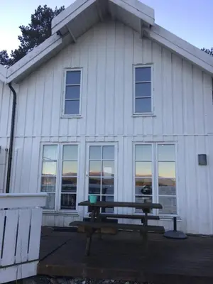 a picnic table in front of a white building at Sponavik Camping in Stord
