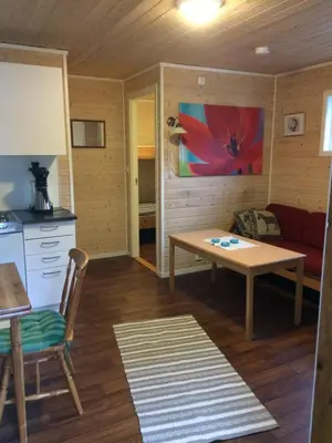 a kitchen and living room with a table and a couch at Sponavik Camping in Stord