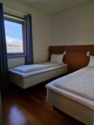 two beds in a room with a window at Bjugn Hotell in Botngard