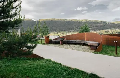 a skate park with a bench and mountains in the background at Thon Hotel Vinstra in Vinstra
