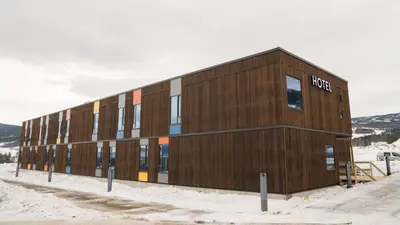 a wooden building with the word hotel on it in the snow at Thon Hotel Vinstra in Vinstra