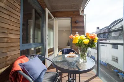 a table with a vase of flowers on a balcony at BJØRVIKA APARTMENTS, Damsgård Area, Bergen city center in Bergen