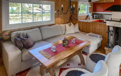 a living room with a couch and a table at Cozy Home In Sjusjøen in Sjusjøen