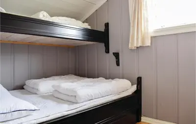 two bunk beds in a room with a window at Sjusjøen Setergrend 4730 in Sjusjøen