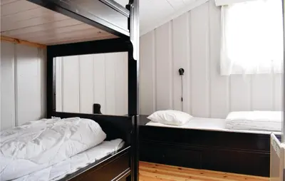 a bedroom with two bunk beds and a window at Sjusjøen Setergrend 4730 in Sjusjøen