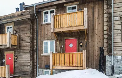 a log cabin with red doors and a deck at Sjusjøen Setergrend 4763 in Sjusjøen