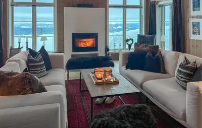 a living room with white couches and a fireplace at Cozy Home In Sjusjøen With Sauna in Sjusjøen
